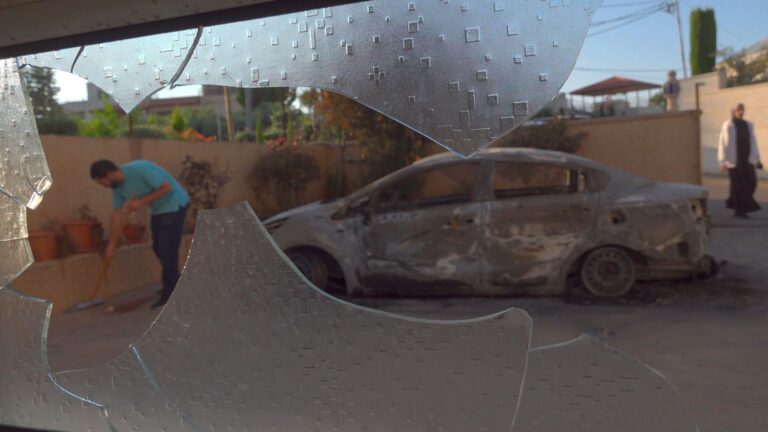 Photo: A Palestinian resident sweeps shards of glass next to burnt cars that were set on fire by Israeli settlers during an attack on the town of Turmus Ayya on 21 June 2023. Eddie Gerald/Alamy Live News
